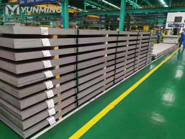 Stacked stainless steel sheets in a warehouse, labeled for easy identification and organization.